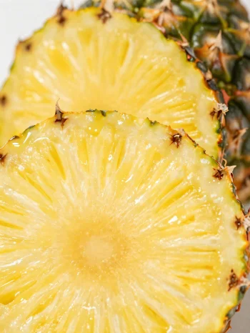 Piña fresca rebanada sobre mesa de madera rústica