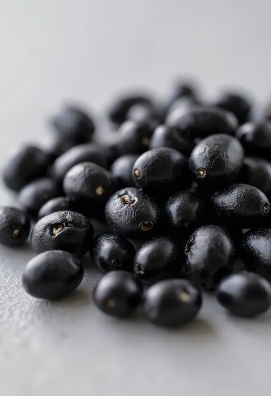 Frijoles negros brillantes, crudos y cocidos en tazón de cerámica y mesa rústica