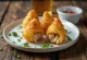 Coxinha sin gluten, crujientes bolitas de pollo decoradas con cilantro fresco