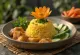 Tumpeng con tempeh, un plato indonesio exótico, arroz rico, tempeh tostado y verduras frescas