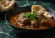 Nihari de res, cocinado en salsa rica especiada, decorado con cilantro fresco