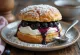 Semla con mermelada de arándanos, servida con crema batida