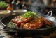 Kimchi's Galbi, rebanadas de carne de res asada, decoradas con cebollín y ajonjolí