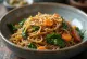 Japchae con salsa de soya servido, con fideos de camote y verduras