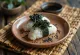 Onigiri relleno de alga kombu, decorado con ajonjolí negro