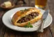 Karjalanpiirakka con relleno de champiñones, servido con perejil fresco