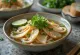 Pho de ajo servido en tazón, sopa de fideos de arroz al ajo, cilantro fresco y rodajas de limón
