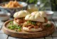Baozi chino al vapor con carne de pato asada, relleno de salsa hoisin, servido en vaporera de bambú