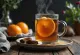 Cider de té y clavo en taza, decorado con rama de canela y rodaja de naranja