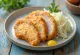 Tazón de tonkatsu con mostaza servido con muslos de pavo y col fresca
