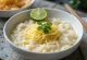 Cháo con jengibre, decorado con jugo de limón fresco y cilantro