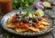 Chilaquiles con Cecina, trozos de tortilla crujiente con cecina y salsa roja