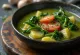 Caldo verde con ajo, servido con abundantes papas, hojas de kale y chorizo.